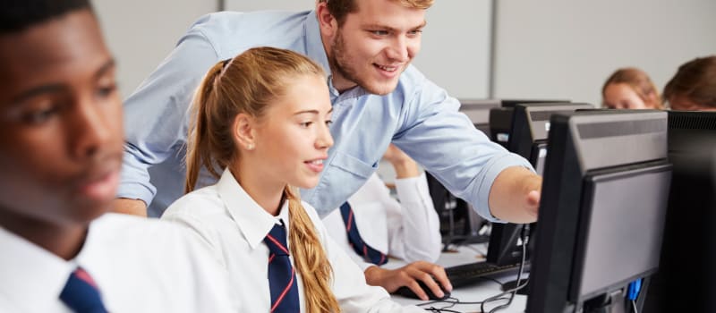 Careers adviser and students looking at computers